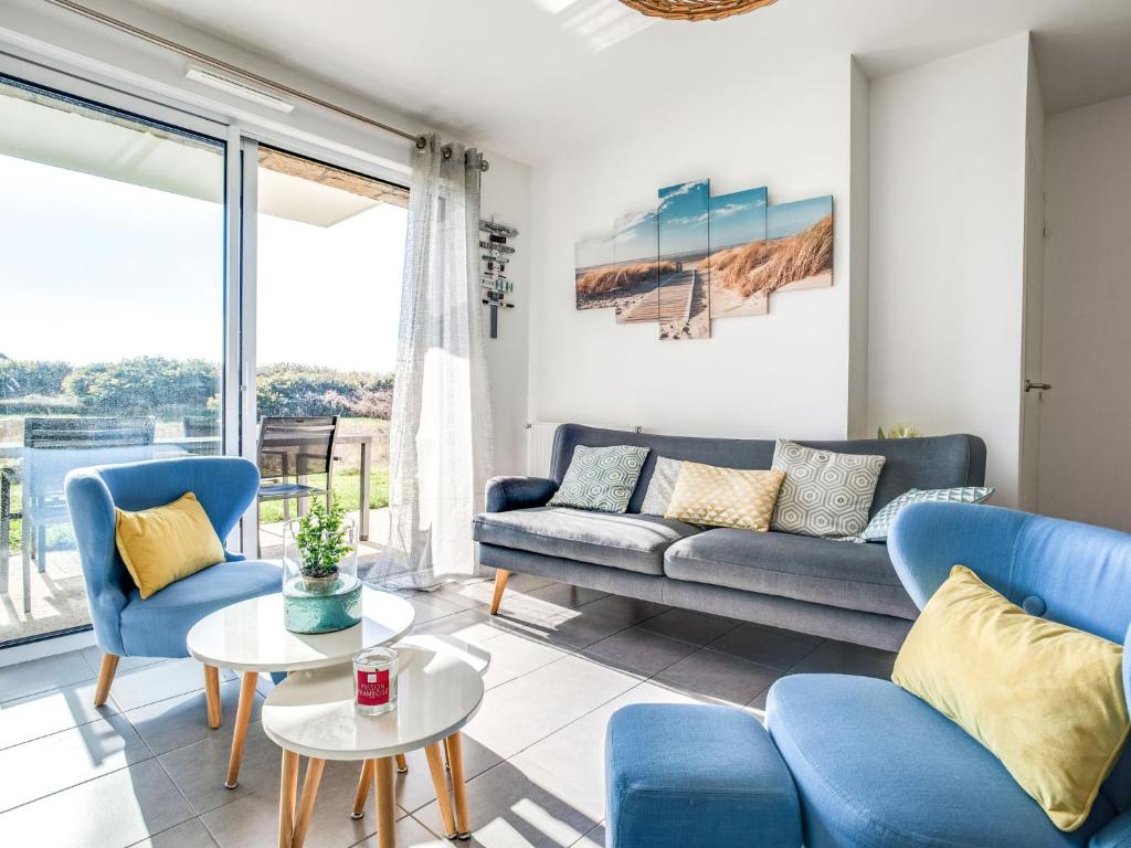 uma sala de estar com cadeiras azuis e um sofá em Apartment Le Domaine de Fort Neuf by Interhome em Port-Haliguen