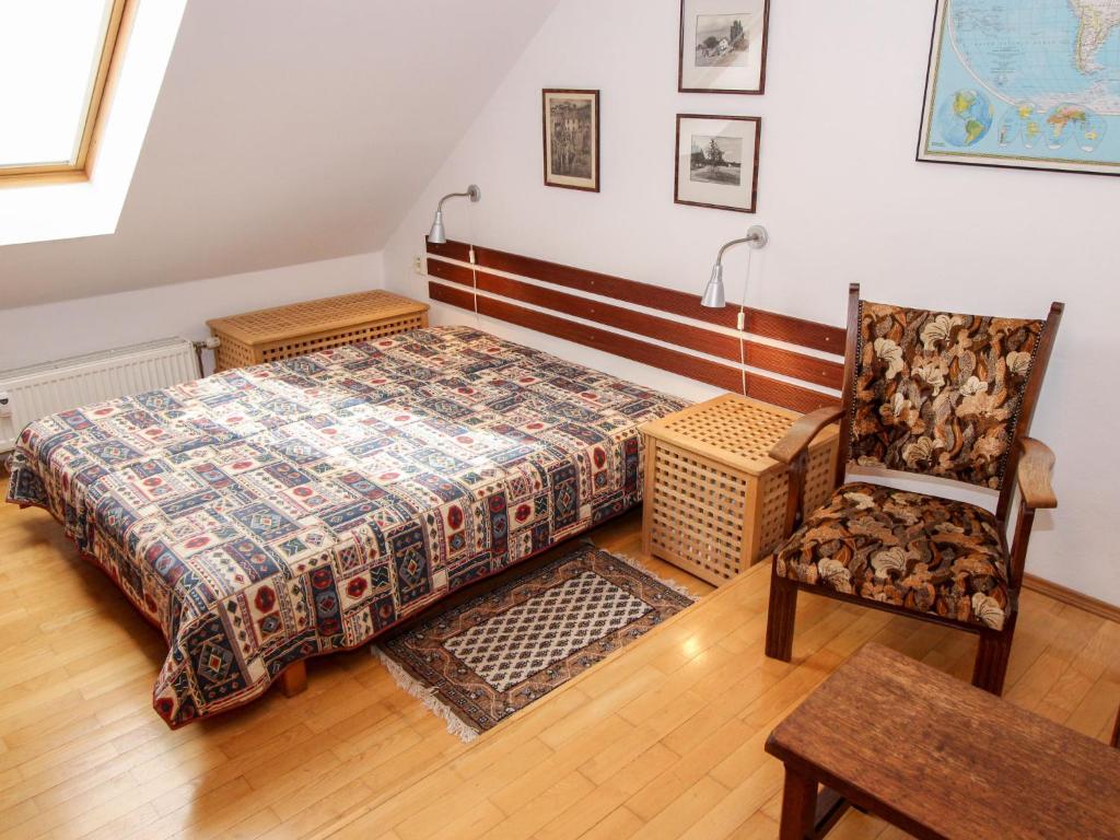 een slaapkamer met een bed en een stoel bij Apartment Hodkovičky by Interhome in Praag