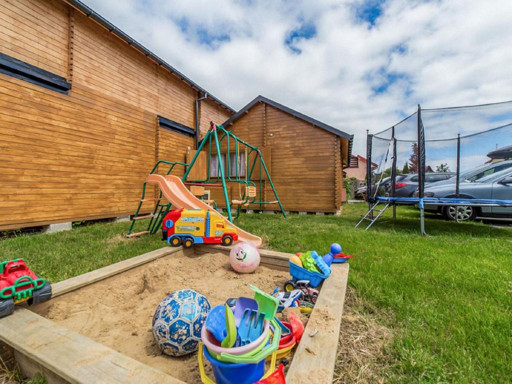 a sandbox in a yard with toys and a playground at Holiday Home Onyx-1 by Interhome in Mielno