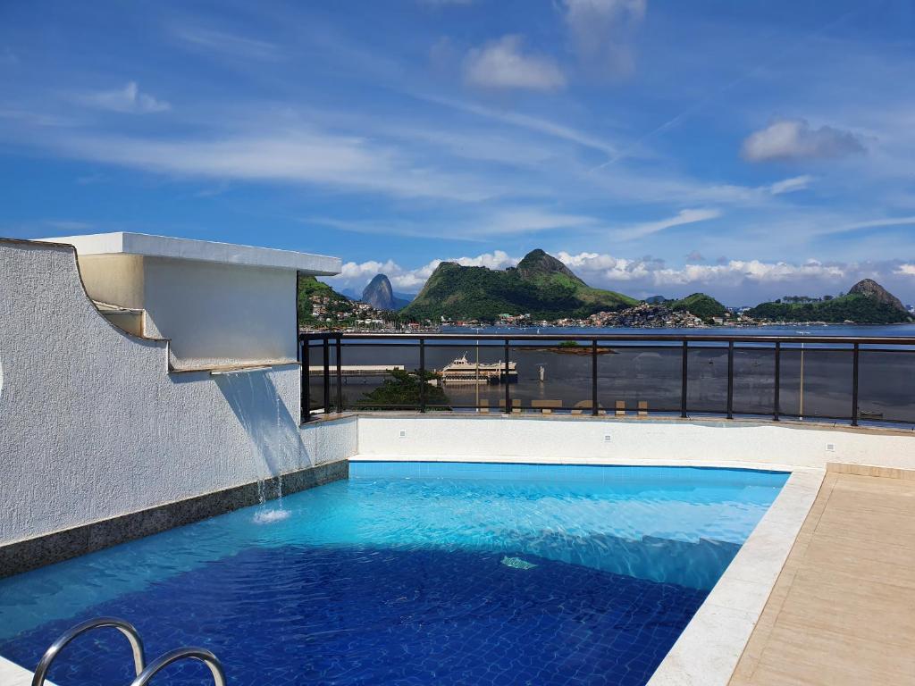 a swimming pool with a view of the water at Hotel Solar do Amanhecer in Niterói