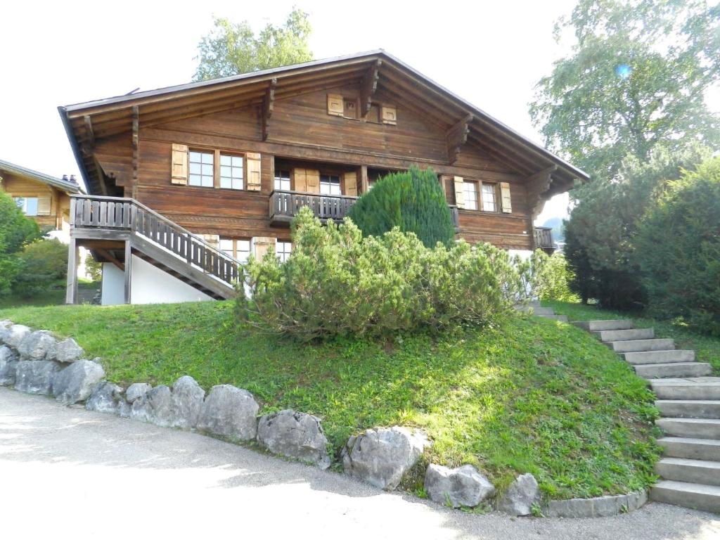 Une grande maison en bois avec des escaliers se trouve juste devant. dans l'établissement Apartment Les Hivernants - 1- Stock rechts by Interhome, à Gstaad