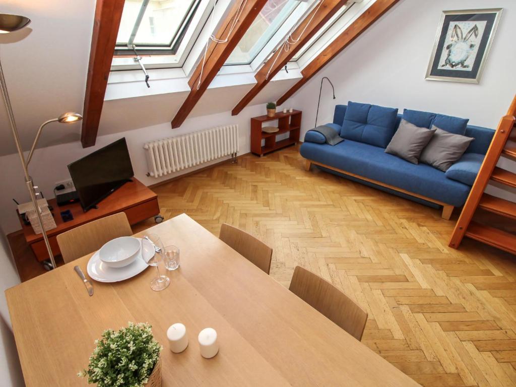 sala de estar con mesa y sofá azul en Apartment O21 by Interhome, en Praga