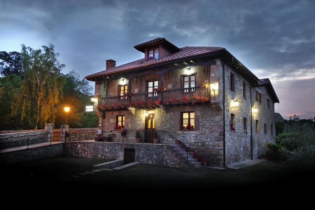 Casa de piedra grande con balcón en la parte superior. en Posada La Solana, en Santillana del Mar