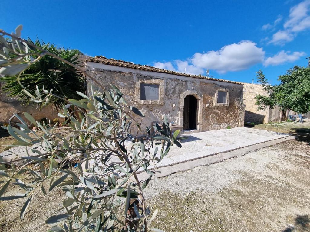 una vieja casa de piedra con un camino que conduce a una puerta en Il Casale Suite&Rooms, en Burgio