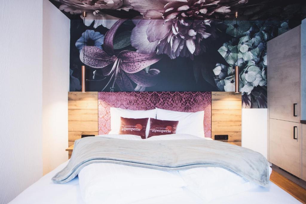 ein Schlafzimmer mit einem großen Bett mit Blumentapete in der Unterkunft Alpenperle Apartments in Ladis