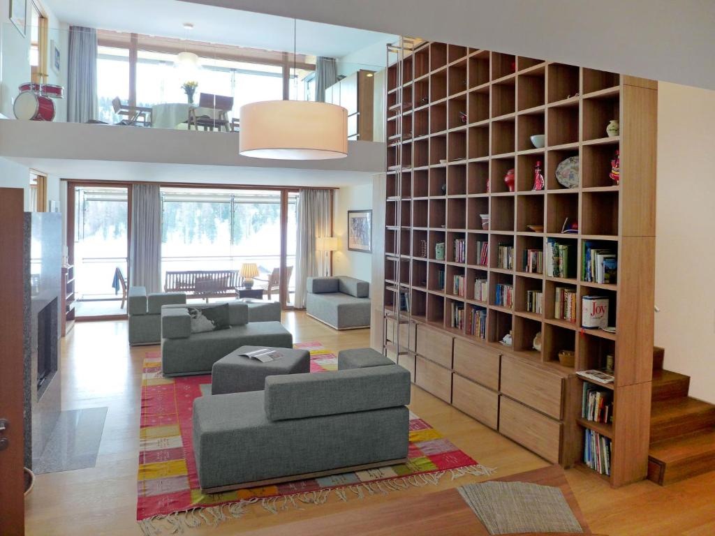 a living room with a book shelf and couches at Apartment Residenz Cresta Kulm B26 by Interhome in Celerina