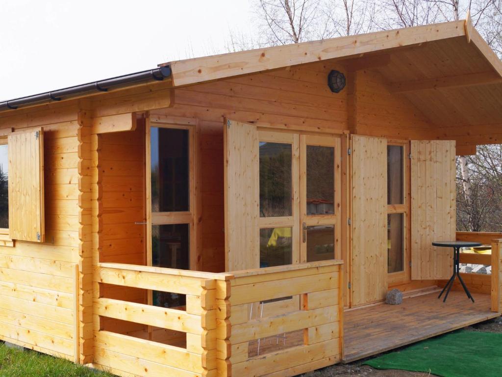 a wooden cabin with a roof and windows at Holiday Home Villa Amber Gąski-4 by Interhome in Gąski