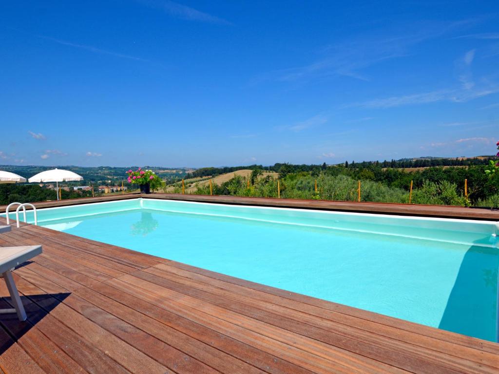 una piscina en una terraza de madera con vistas en Apartment Podere La Torre-2 by Interhome, en Certaldo
