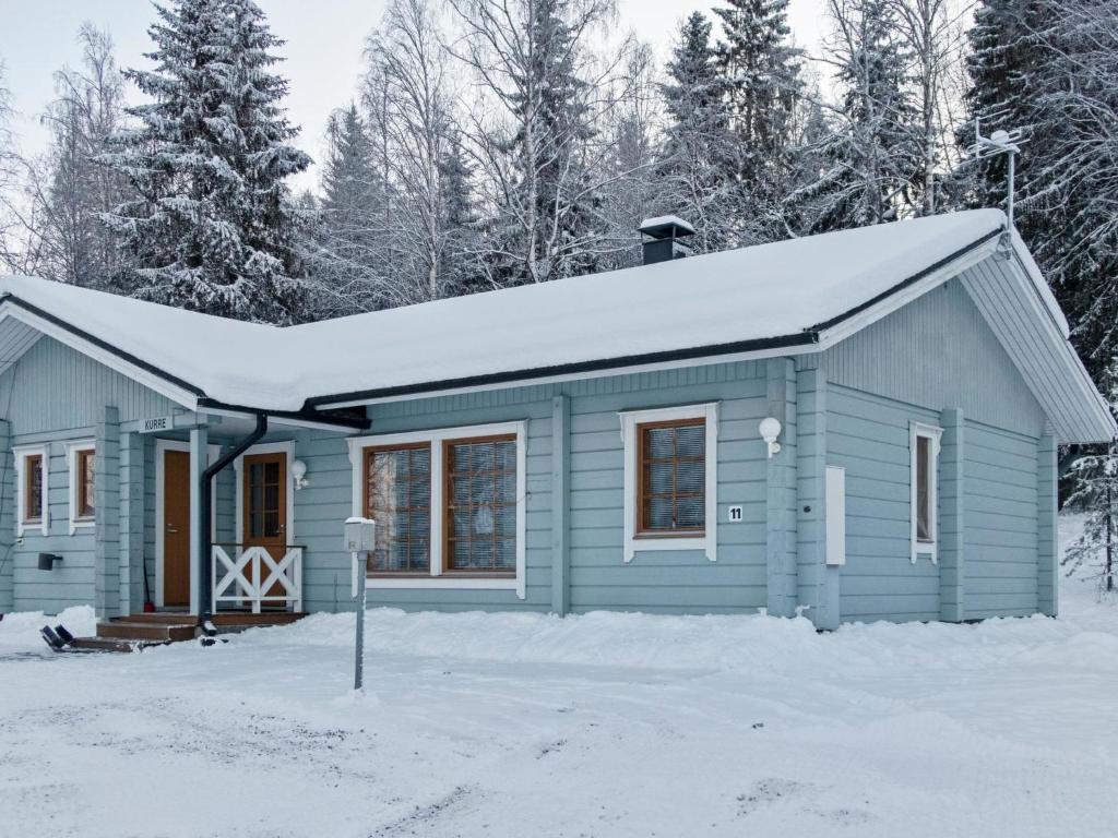 a blue house with snow on top of it at Holiday Home Kurre by Interhome in Lahdenperä