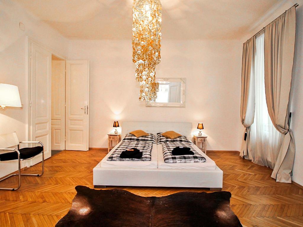 1 dormitorio con cama y lámpara de araña en Apartment Romantic Living by Interhome, en Viena