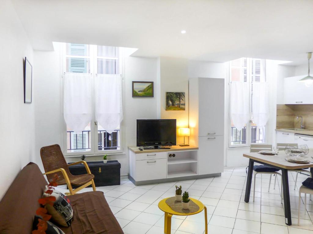 uma sala de estar com um sofá e uma mesa com uma televisão em Apartment Vieux Nice by Interhome em Nice