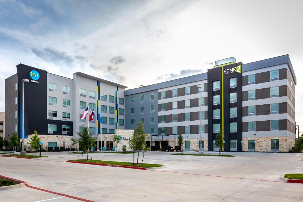 an office building with a parking lot in front of it at Tru by Hilton Pflugerville, TX in Pflugerville