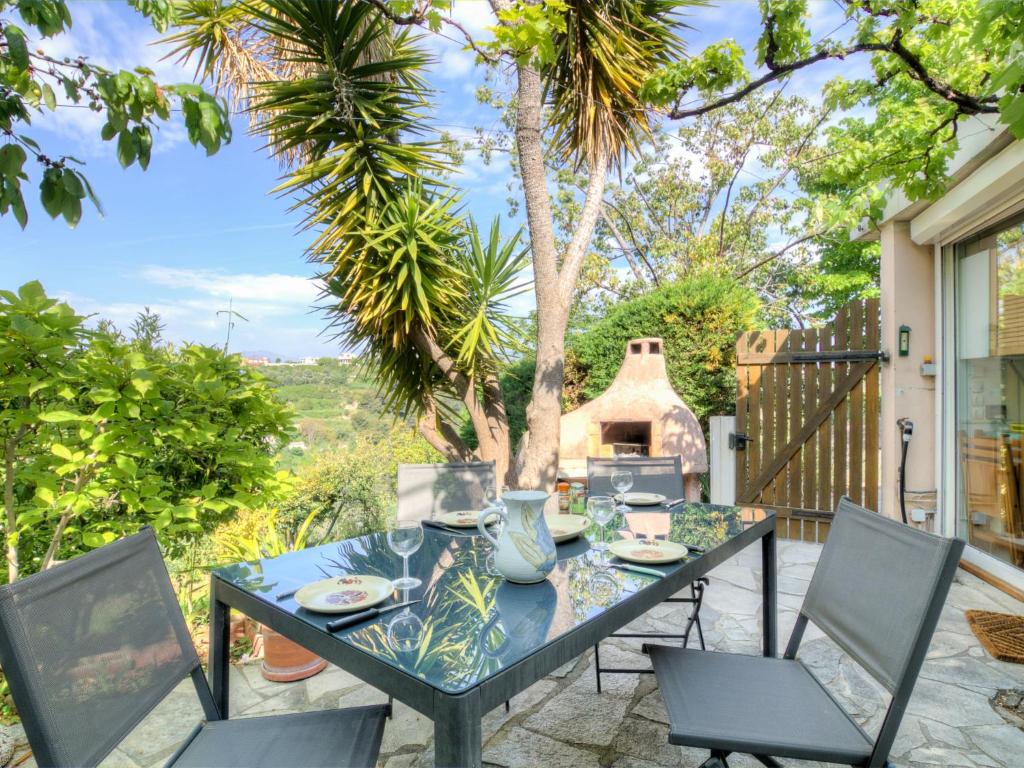 een patio met een tafel en stoelen en een pizza-oven bij Holiday Home Agora by Interhome in Nice
