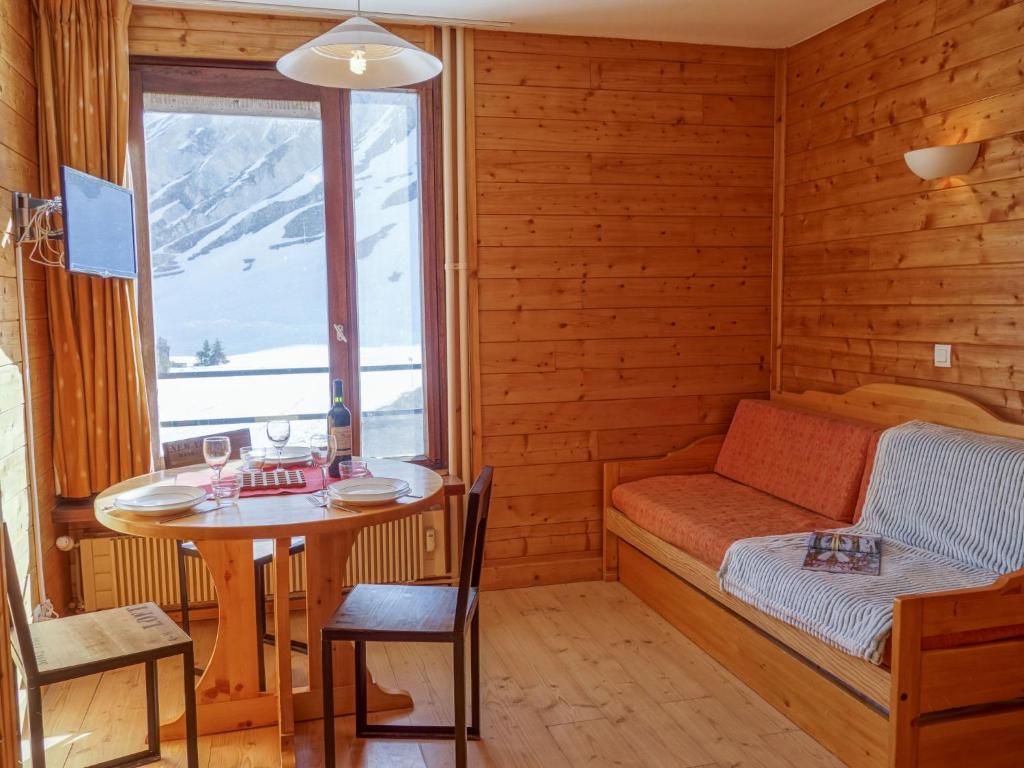 Cette chambre comprend une table, un lit et une fenêtre. dans l'établissement Studio Les Moutières B1 et B2 - Val Claret-23 by Interhome, à Tignes