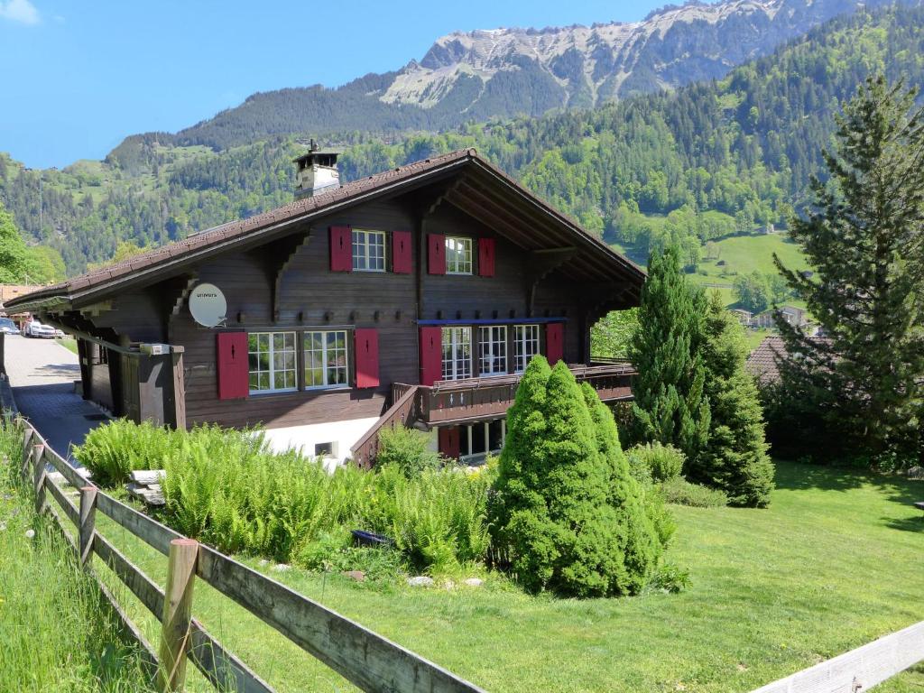 a house in the mountains with a fence at Chalet Chalet am Schärm by Interhome in Lauterbrunnen
