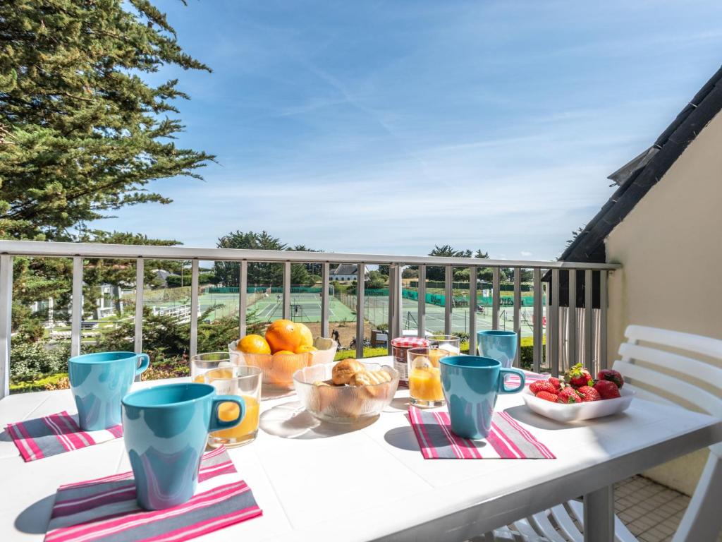 - une table avec des fruits et des boissons sur le balcon dans l'établissement Apartment Rose des Vents-1 by Interhome, à Port-Haliguen