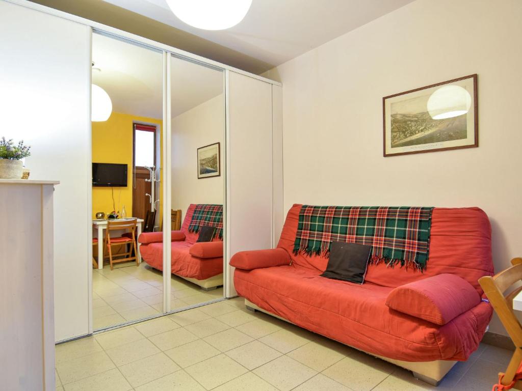 トゥルヴィル・シュル・メールにあるApartment Bonsecours by Interhomeのリビングルーム(赤いソファ、テーブル付)