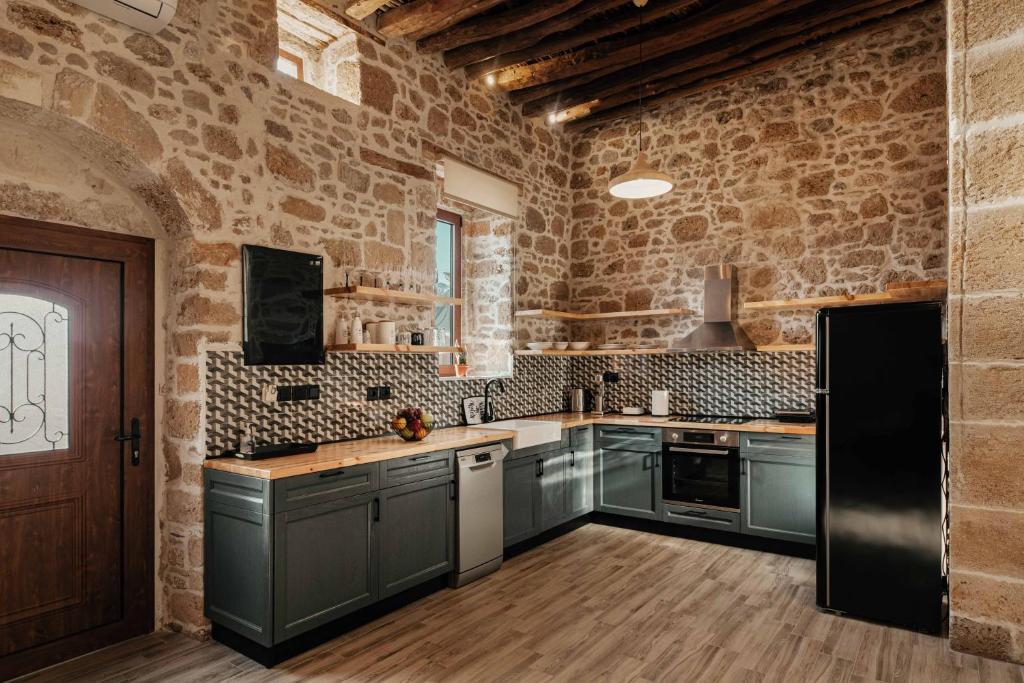 kuchnia z szarymi szafkami i ceglaną ścianą w obiekcie La casa dell'arch w mieście Charaki
