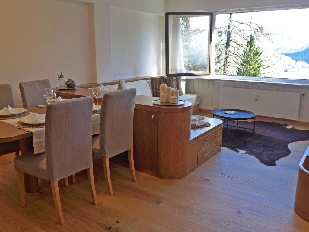 uma sala de jantar com uma mesa e cadeiras e uma janela em Apartment Chesa Cripels I by Interhome em St. Moritz