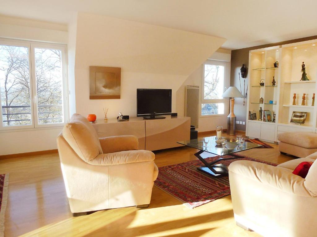 a living room with two chairs and a television at Apartment Elisa-2 by Interhome in Trouville-sur-Mer