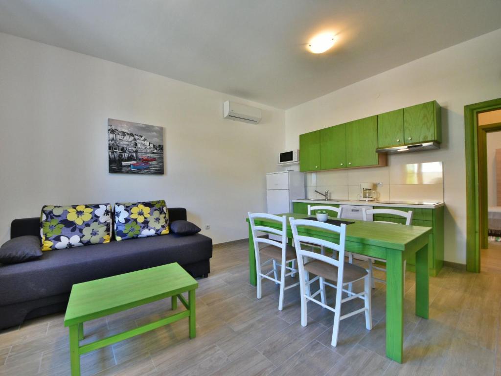 eine Küche und ein Wohnzimmer mit einem Sofa und einem Tisch in der Unterkunft Apartment Val-1 by Interhome in Sveti Juraj