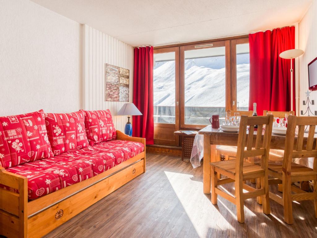 a living room with a red couch and a table at Apartment Les Grandes Platières-22 by Interhome in Tignes