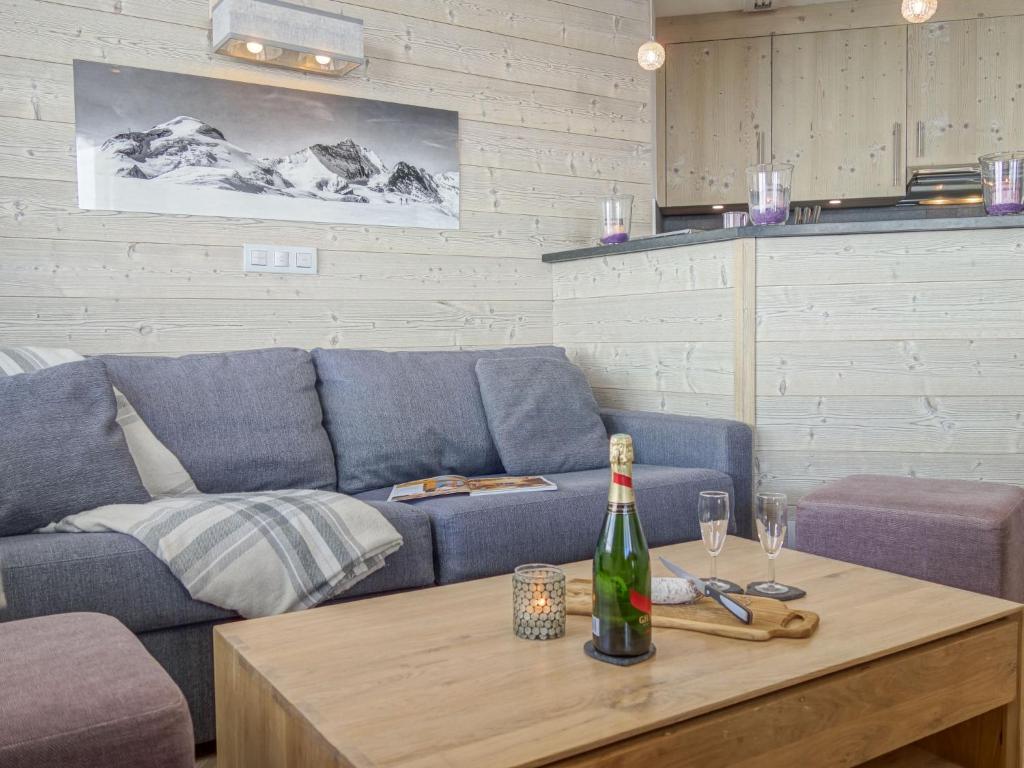 uma sala de estar com um sofá e uma garrafa de vinho numa mesa em Apartment Le Curling B - Val Claret-35 by Interhome em Tignes