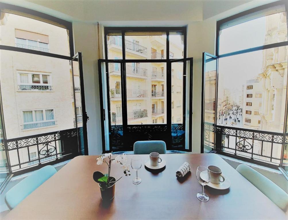 a dining room with a table and large windows at Apartamentos Vega by gaiarooms in Salamanca