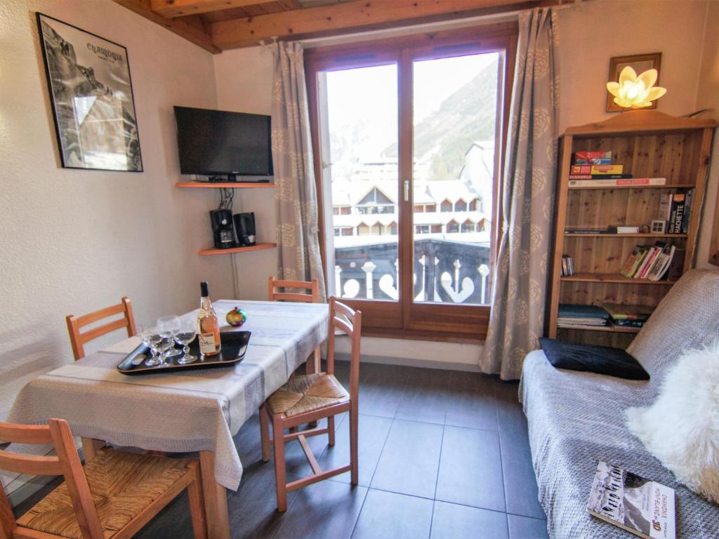 sala de estar con mesa, sofá y ventana en Apartment Le Triolet-8 by Interhome, en Chamonix-Mont-Blanc