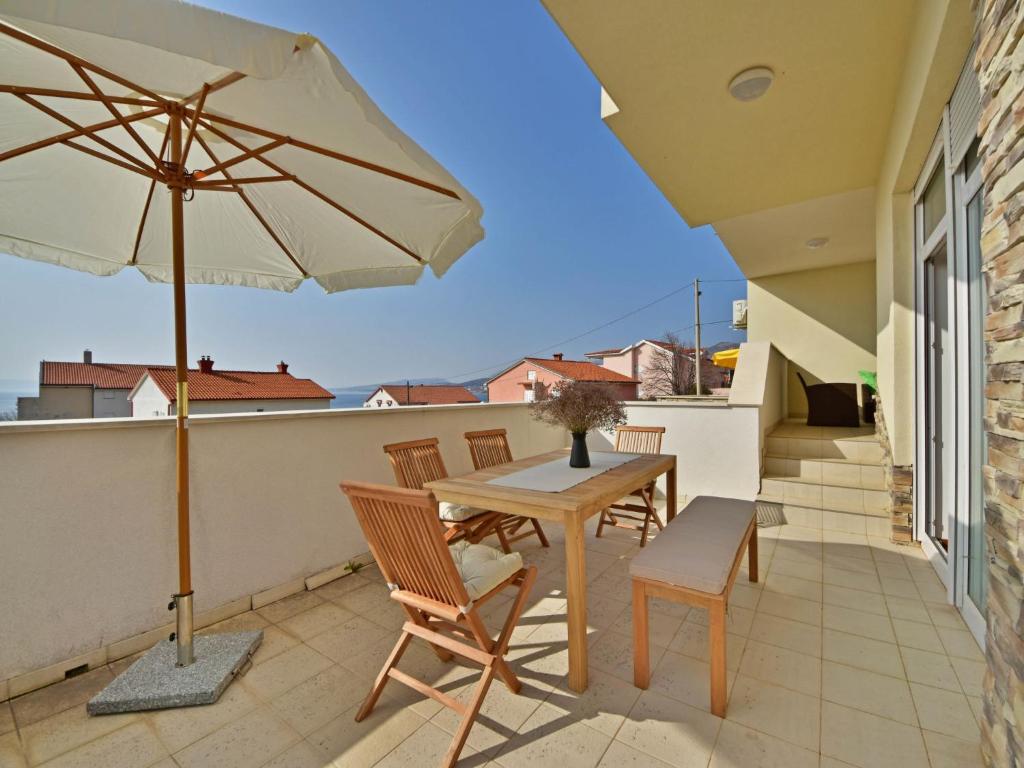un patio con mesa, sillas y sombrilla en Apartment Cvit-2 by Interhome, en Klenovica