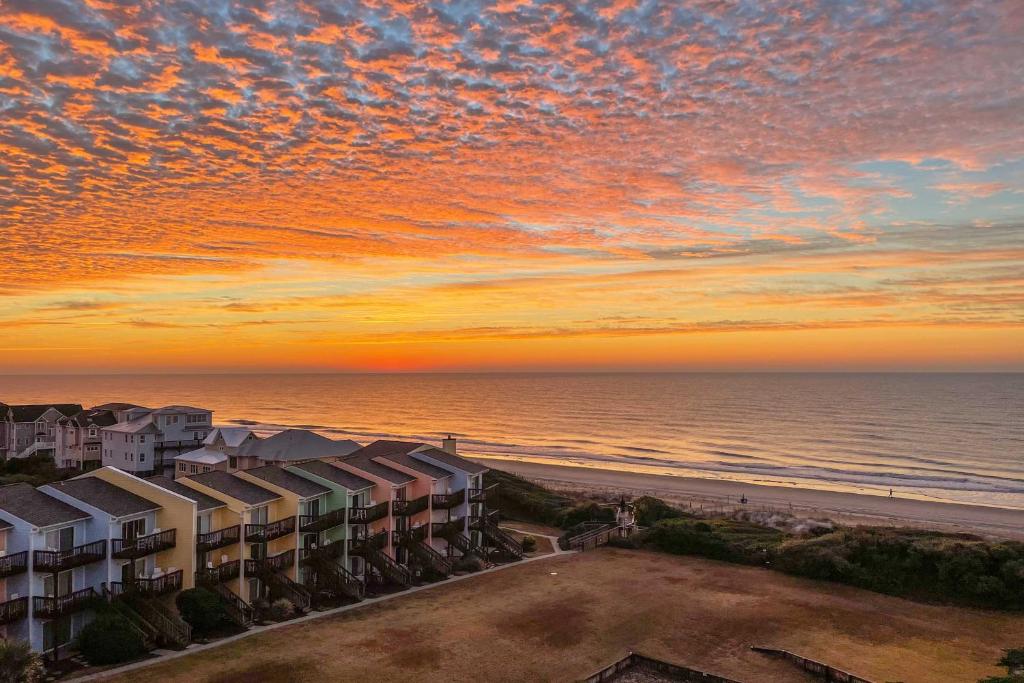 a view of the beach and the ocean at sunset at Emerald Isle Condo with Direct Access to Ocean! in Emerald Isle