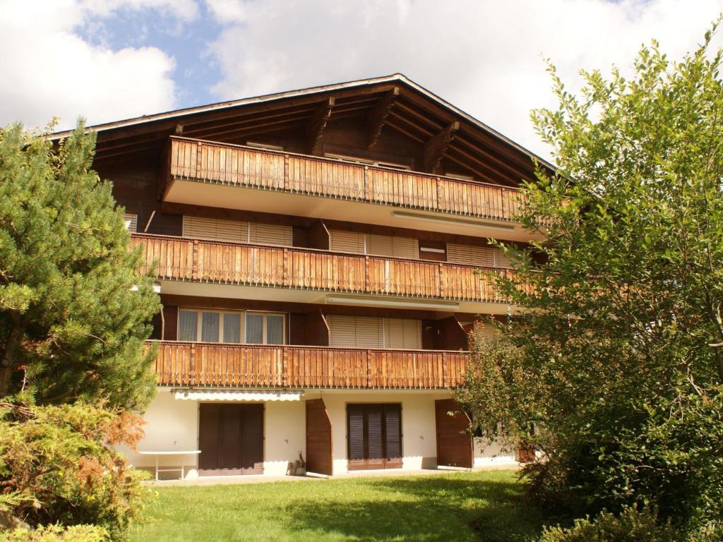 a building with balconies and trees in front of it at Apartment Kristall by Interhome in Zweisimmen
