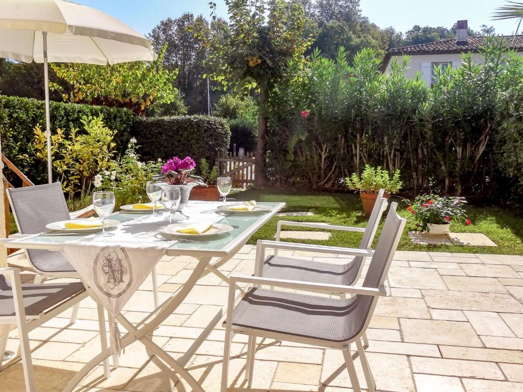 a table with chairs and an umbrella on a patio at Apartment Village Marin-16 by Interhome in La Foux