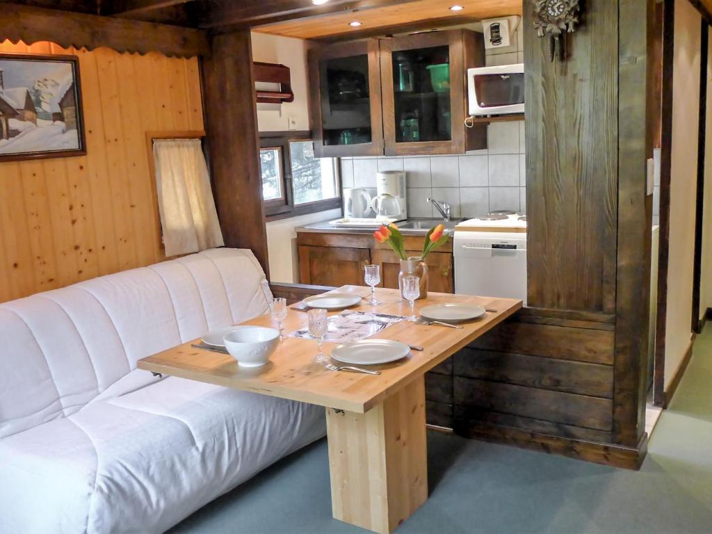 salon ze stołem i białą kanapą w obiekcie Apartment Grand Roc-4 by Interhome w Chamonix-Mont-Blanc