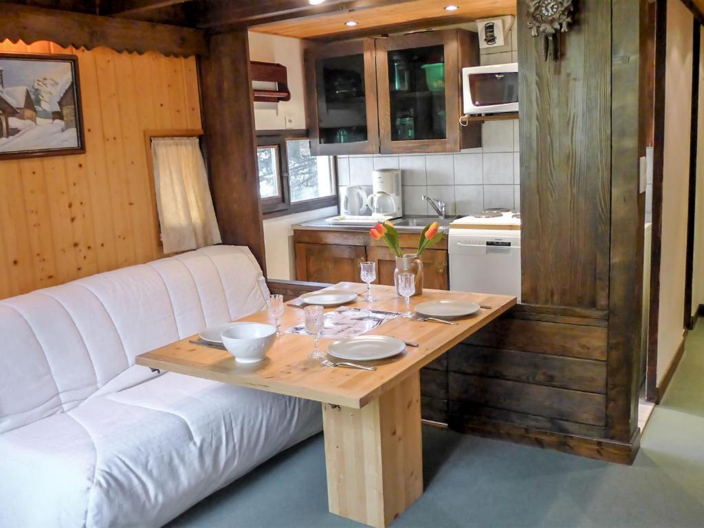 un salon avec une table et un canapé blanc dans l'établissement Apartment Grand Roc-4 by Interhome, à Chamonix-Mont-Blanc