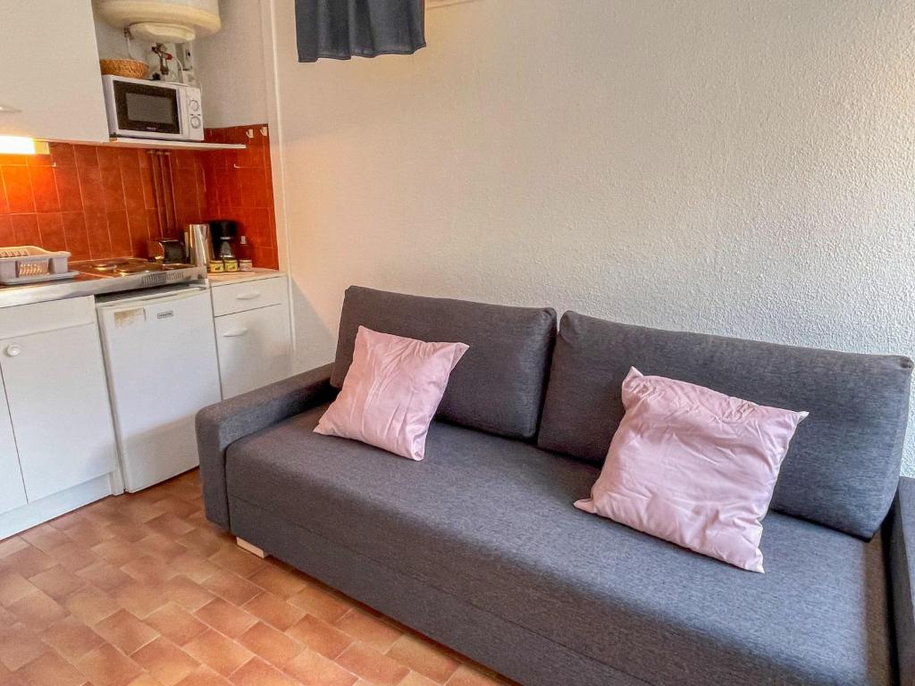 ル・グロー・デュ・ロワにあるStudio Le Cabestan-3 by Interhomeのキッチンにピンクの枕2つが付いたソファ