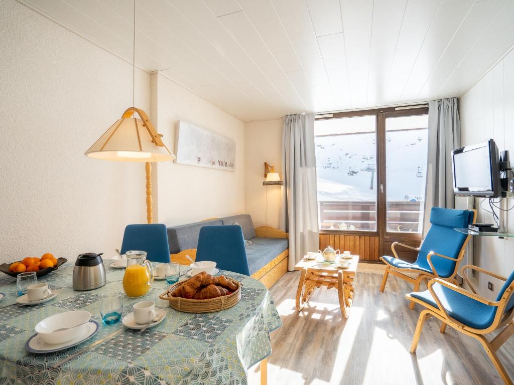 un salon avec une table et des chaises bleues dans l'établissement Apartment Les Tommeuses - Val Claret-29 by Interhome, à Tignes