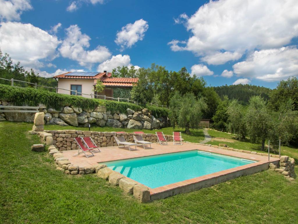 een zwembad in een tuin met stoelen en een huis bij Holiday Home Casa la Selvolina by Interhome in Roccastrada