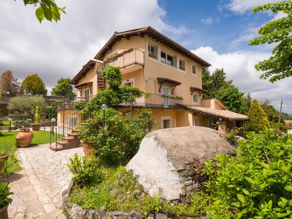 una casa con una gran roca delante de ella en Villa Vista da Rocca di Papa-1 by Interhome, en Rocca di Papa