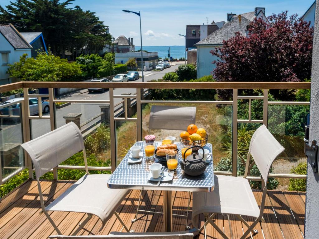 Una mesa con un bol de fruta en un balcón. en Apartment Les Néréïdes by Interhome, en Quiberon