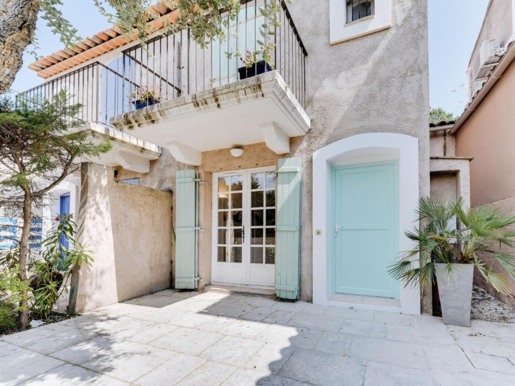 a house with a blue door and a balcony at Holiday Home Les Parcs de Gassin-9 by Interhome in Saint-Tropez