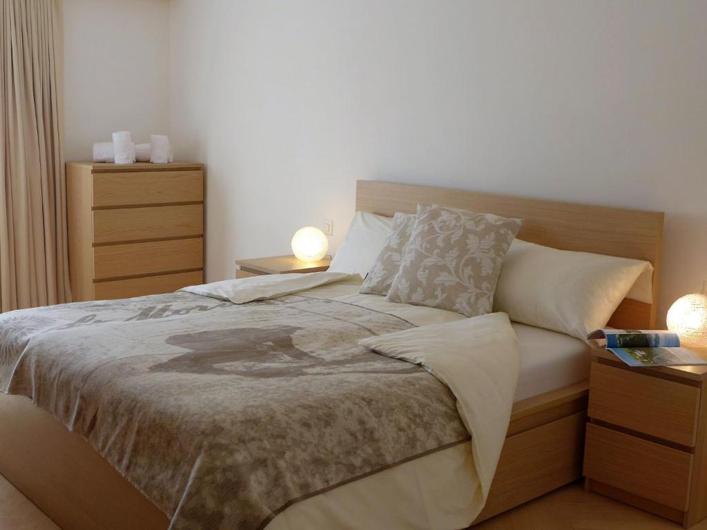 um quarto com uma cama grande e 2 mesas de cabeceira em Apartment Chesa Sur Ova 21 by Interhome em St. Moritz