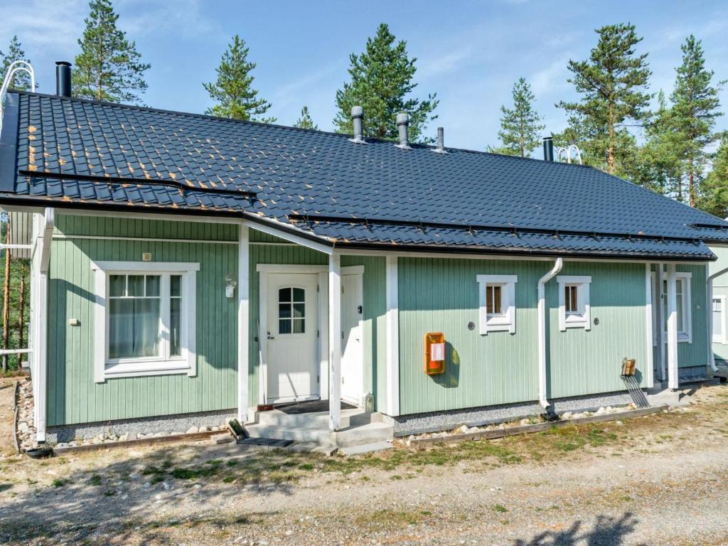 ein grünes Haus mit grauem Dach in der Unterkunft Holiday Home Saunaharju 3 by Interhome in Kolinkylä