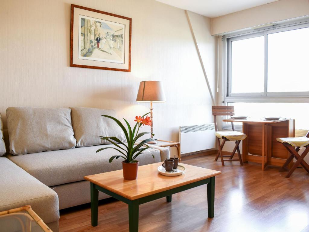 ein Wohnzimmer mit einem Sofa und einem Tisch in der Unterkunft Apartment Le Polo by Interhome in Deauville