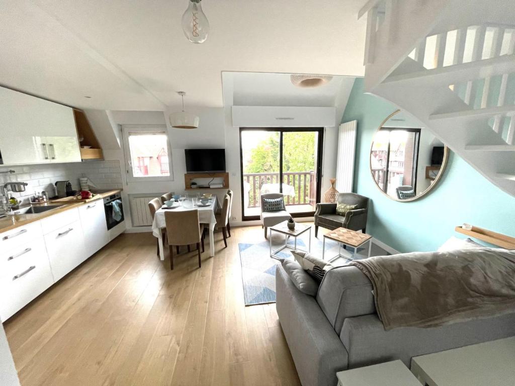 a kitchen and living room with a couch and a table at Apartment Le Fairway-5 by Interhome in Deauville