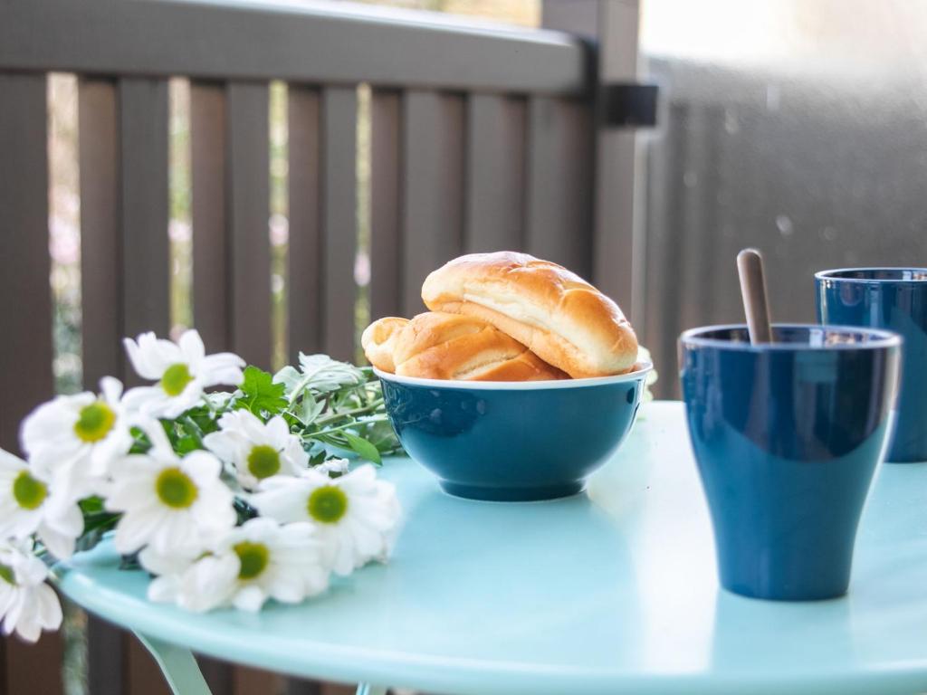 - un bol de croissants assis sur une table avec des fleurs dans l'établissement Apartment l'Hermitage-2 by Interhome, à Deauville