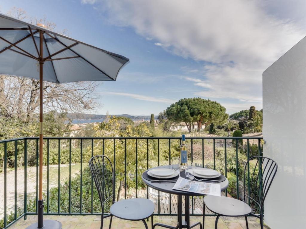 a table with chairs and an umbrella on a balcony at Studio Bella Vista by Interhome in Saint-Tropez