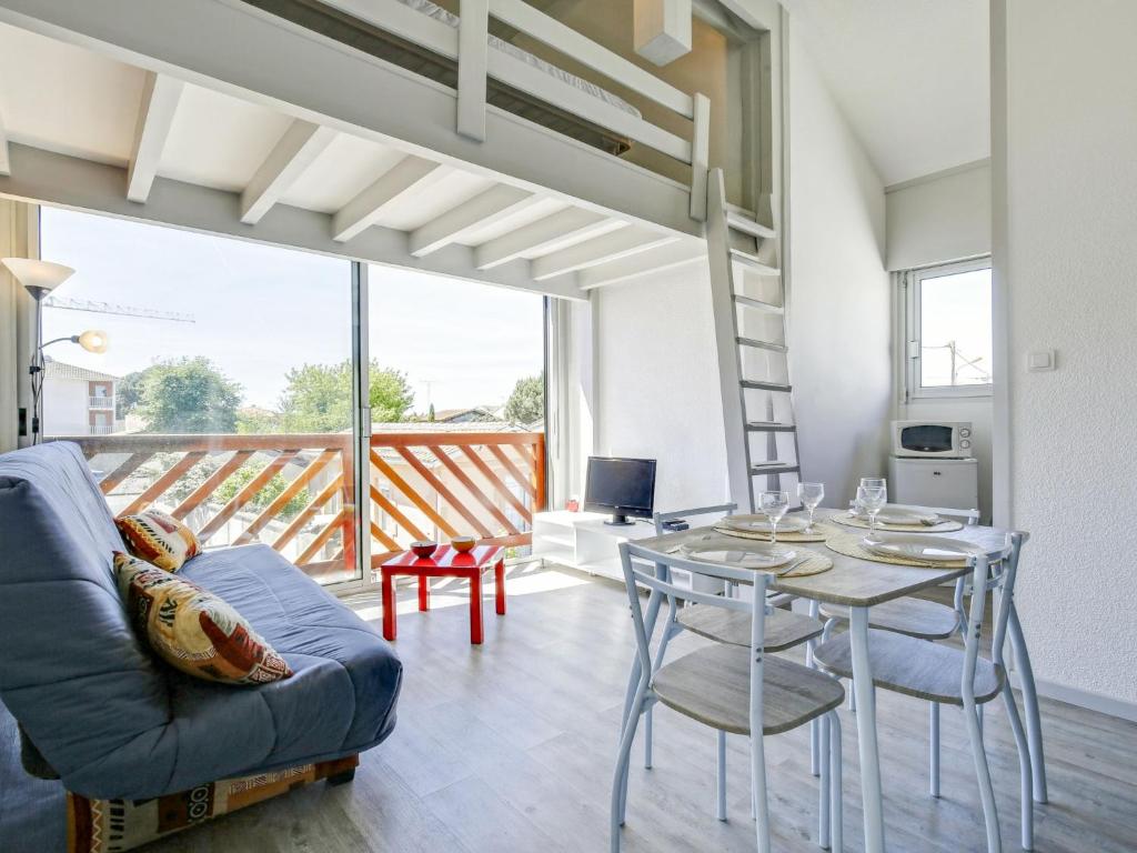 een woonkamer met een tafel en stoelen en een balkon bij Studio La Passerelle by Interhome in Gujan-Mestras