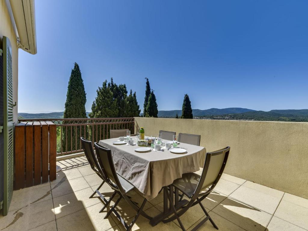 a table and chairs on a balcony with a view at Apartment Les Terrasses de Grimaud by Interhome in Grimaud