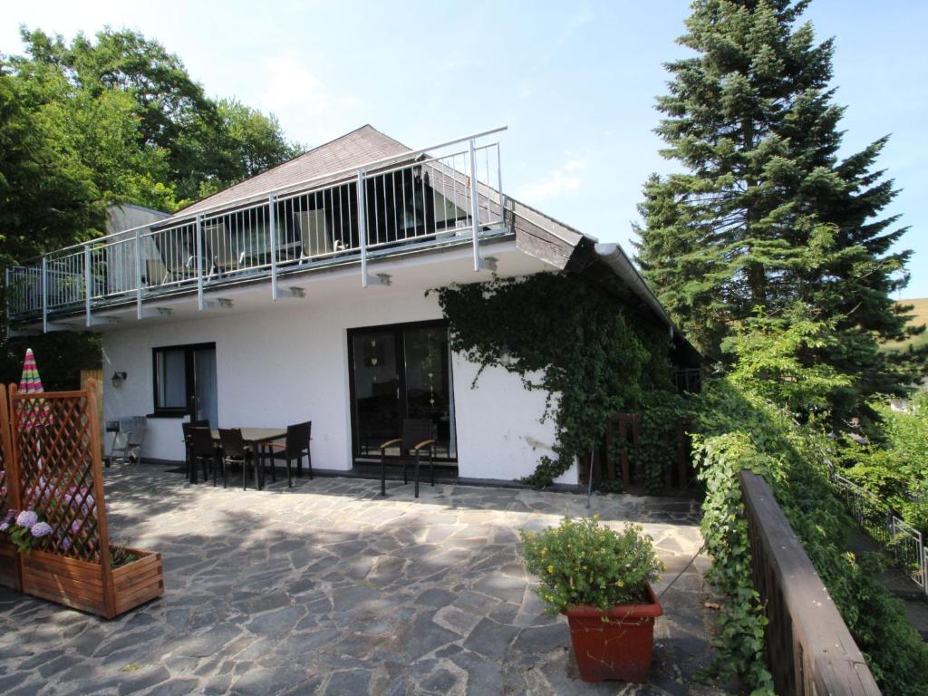 a house with a balcony and a patio at Apartment Eifelnatur - Haus 2-1 by Interhome in Immerath